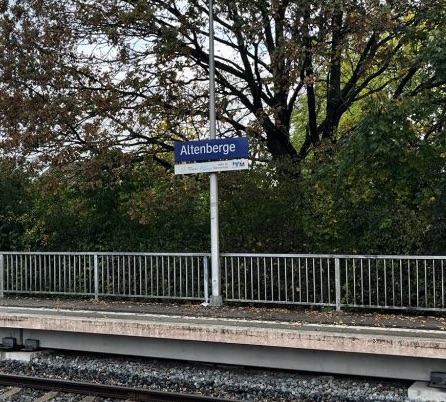 Bahnhoofsschild Altenberge mit einem Teil des Bahnsteigs